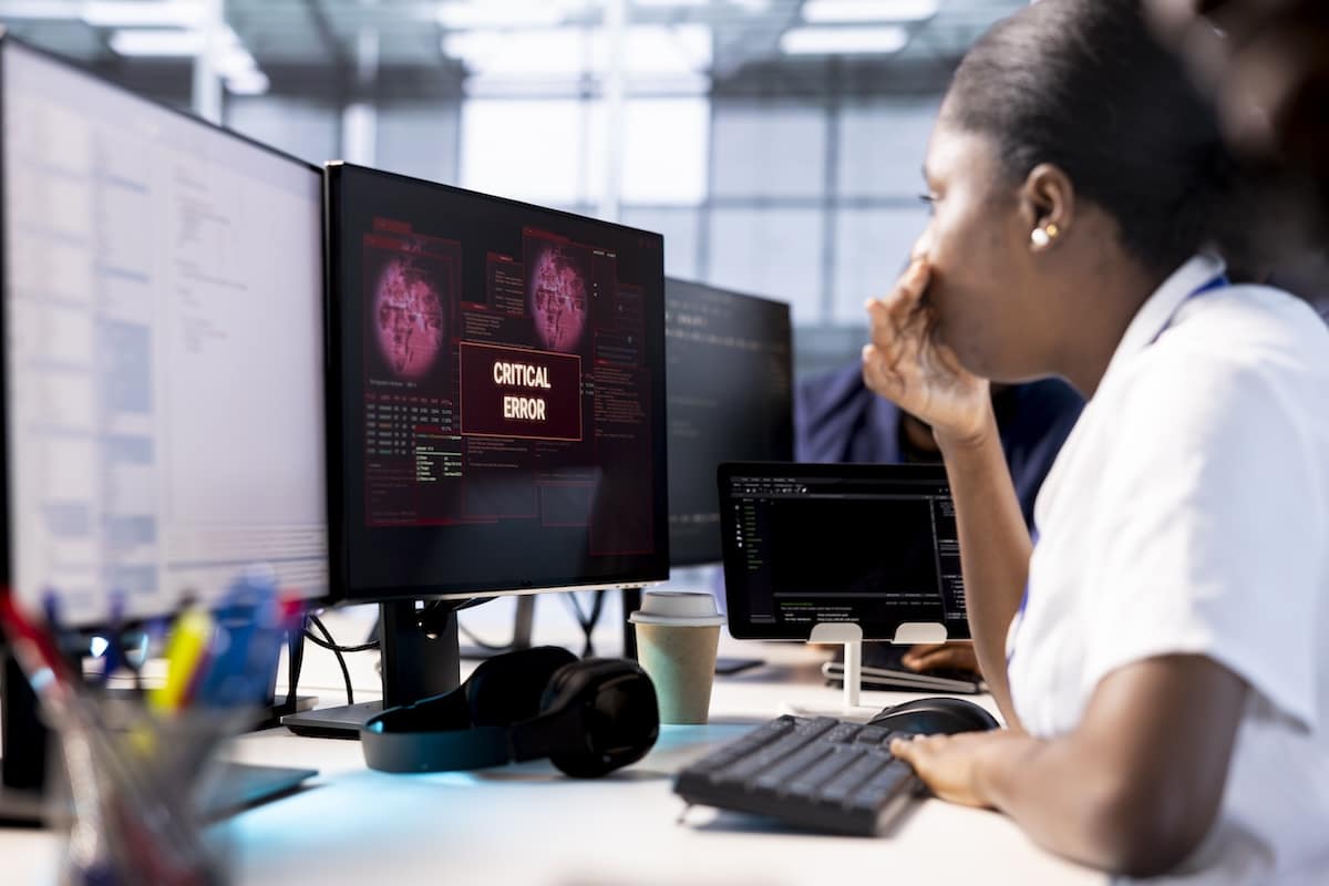 Anxious cybersecurity employee panicking while monitoring security incidents affecting server hub network system, worrying after seeing critical error affecting infrastructure racks